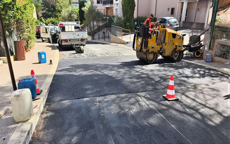 Reprise d'une chaussee en pente : compactage au rouleau, balisage par cones